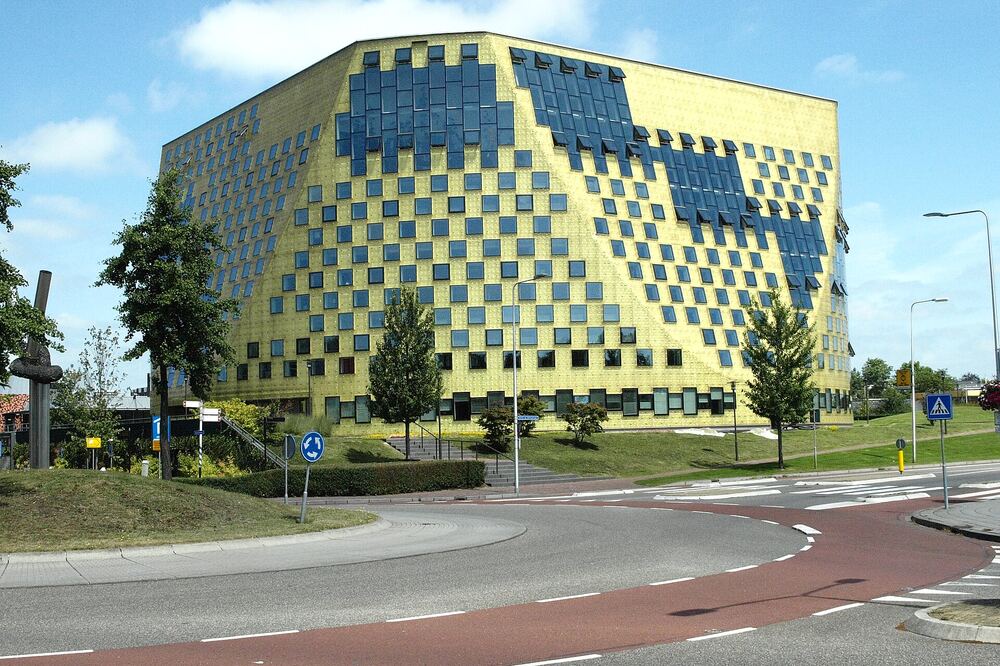 Het goudgele, moderne gemeentehuis van Hardenberg met zijn opvallende geblokte gevel onder een blauwe lucht